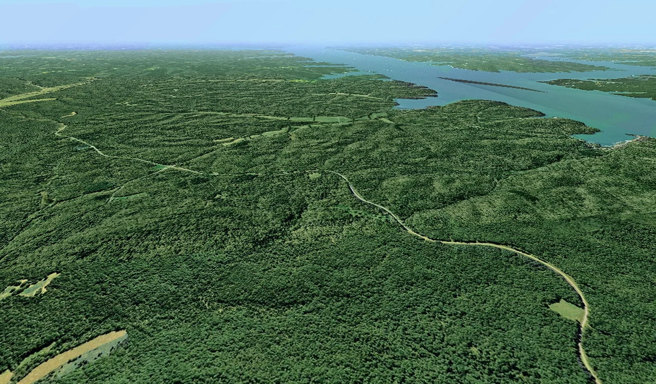 Scope and content: The original finding aid described this photograph as:
Original Caption: An aerial view of a vast green landscape highlights the Woodlands Trace byway as it winds its way through the forested peninsula called Land Between The Lakes National Recreation Area.
Location: (36.901° N 88.088° W)
Status: Public domain.